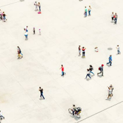 Open plein met mensen die lopen, staan en met elkaar praten; rechtsonder fietst iemand over betonnen tegels.