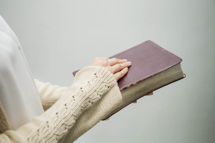 Vrouw die een dicht boek vasthoudt.