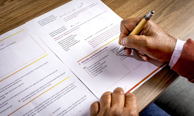 papieren op tafel met een hand met een pen