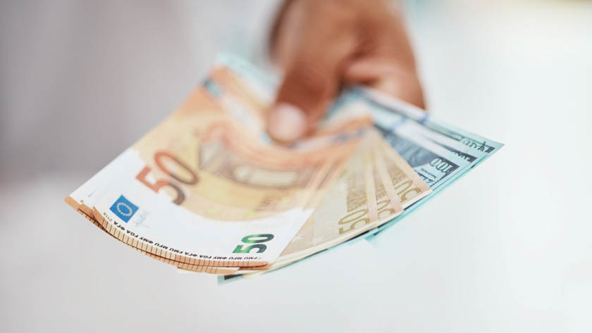 Hand die meerder eurobiljetten vastheeft.