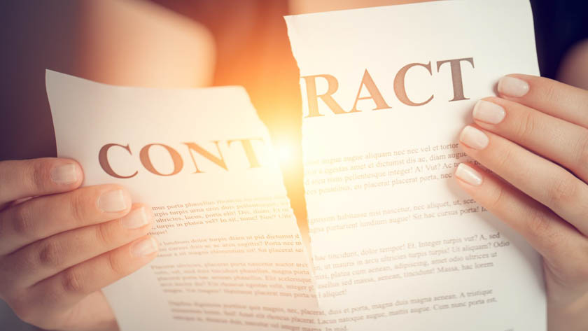 Handen van een persoon die een gescheurd contract vasthoudt.