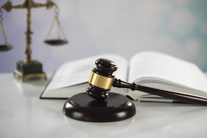Bureau met gavel, een boek en een weegschaal.