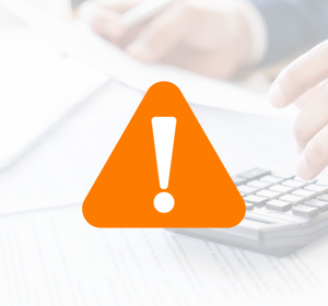 Oranje waarschuwingspictogram met een uitroepteken op een achtergrond van een persoon die rekent met een rekenmachine en documenten op een bureau.