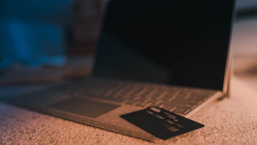 Laptop met bankpas in avondlicht.