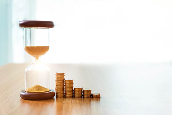 Gouden zandloper en een vijf stapels munten ernaast, die afnemen in hoogte.