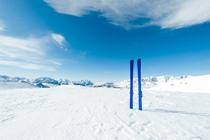 Twee blauwe ski's, staand geplaatst in de sneeuw.