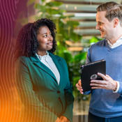 Twee professionals in gesprek op kantoor, een met een tablet