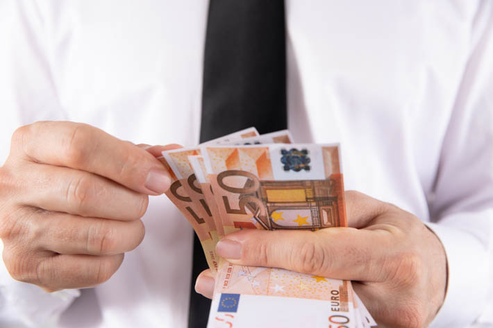 Persoon met biljetten van 50 euro in zijn handen.